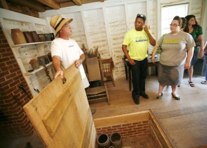 AW062210archaeologyPD5176 Terry and Sarah Hodges listen to tour guide Frank Webster, left, talk about the standalone kitchen at Riverside, the Farnsley-Moremen Landing, during the Project Archaeology workshop in Louisville June 22, 2010. Terry Hodges is a kindergarten assistant at Tully Elementary School (Jefferson County), and Sarah Hodges is a 3rd-grade teacher at Greenwood Elementary School (Jefferson County). Photo by Amy Wallot