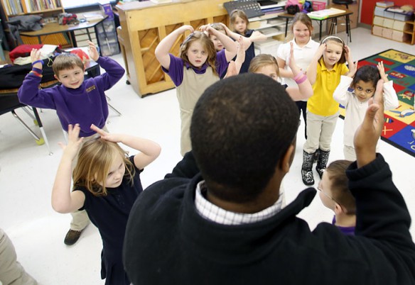 Lederrick Wesley leads 1st-grade students to put their hands on their heads during his music class. Photo by Amy Wallot, Jan. 23, 2013