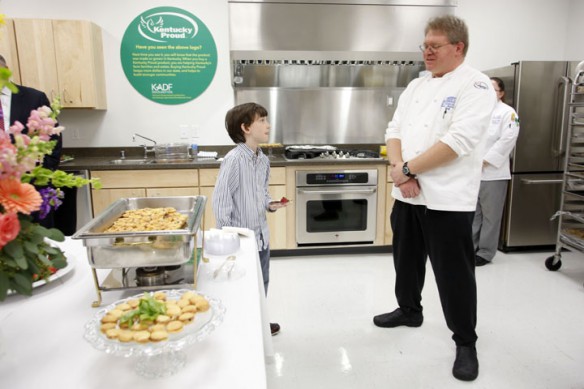 Richardsville Elementary School (Warren County) 5th-grade student Christian Currans talks with Brad Mitchell, executive chef of the Governor's Mansion, about the Kentucky Proud items that were served during the Capitol Education Center open house in Frankfort, Ky. Photo by Amy Wallot, Feb. 8, 2013