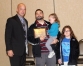 KAHPERD President Jamie Sparks congratulates D'Artagnan Coots, who was named KAHPERD Health Education Teacher of the Year. Pictured with Coots are his two daughters. Submitted photo by Jess Lawrence of Carin Guidance