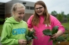 Kara Adams, left, and Jenna Hunt laugh after trying freshly picked kale from their raised garden beds at Rowan County Middle School. Photo by Bobby Ellis, May 18, 2016