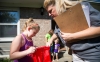 Jadelyn Cook, left, a student at Saffell Street Elementary School (Anderson County), and Elizabeth Harley, her 2nd-grade teacher, peek inside a drawstring backpack during Harley's visit to Cook’s home as part of the school’s Home Visit Blitz. Photo by Bobby Ellis, Aug. 8, 2016