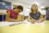 Second-grade students Nathalie Puntos and Allison Davis work on their portraits. Photo by Amy Wallot, May 15, 2014