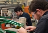 Nick Stinson, left, a senior at Breckinridge County Area Technology Center, and Will Farmer, a carpentry instructor at the school, use scroll saws to cut out detail pieces for a wooden version of the Kentucky Department of Education's logo that will be displayed in KDE's offices in Frankfort. Photo by Bobby Ellis, Dec. 21, 2016