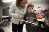 Mary Fryer instructs 3rd-grade student Weston Wint what to do after finishing his aboriginal art inspired pairing at Clay Elementary School (Webster County). Photo by Amy Wallot, Jan. 28, 2015