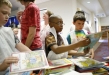 Third-grade student Jason McDonald, center, chooses a book to read to his 2nd-grade partner during the Literacy Cafe at Crossroads Elementary School (Campbell County). Photo by Amy Wallot, May 15, 2012