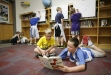 Second-grade student Connor Webster listens to 3rd-grade student Aaron Stewart reading Fox in Socks during the Literacy Cafe at Crossroads Elementary School (Campbell County). Behind them, students fill in posters with who they like to read with and what they like to read about.
