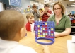 Teacher Amy Pavona plays Connect Four with 4th-grade student D\'Onta Lane during an indoor recess at Dixie Elementary Magnet School (Fayette County) Jan. 6, 2011. Looking on, Brennan Aulds, left, Kendrick Curry, center, and Drew Hensley realize D\'Onta is going to win the game. Photo by Amy Wallot