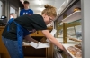 Lacey Trumbo grabs a glazed doughnut for a customer at Metcalfe County High School's Old School Café. Photo by Bobby Ellis, May 24, 2017
