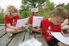 Second-grade students Emily Gray, Cyan Duvall and Ryan Smith read over instructions to test stream water for nutrient levels at Glenn Marshall Elementary School (Madison County). Photo by Amy Wallot, May 9, 2014