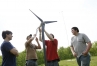 Seniors Zach Hogan, Zack Duff, Branden Elliott and sophomore Cade Allshouse work on the demonstration wind turbine they use for presentations at Grant County Career and Technology Center. In the distance behind them is an 80 foot wind turbine. Photo by Amy Wallot, May 16, 2013