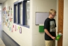 As a member of the Power Police, 8th-grade student Ben Richey leaves a notice on the door of an empty classroom to turn the lights off at Royal Spring Middle School (Scott County). Photo by Amy Wallot, May 26, 2015
