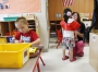Henderson County High School senior Kati Rhodes helps a student put on an apron before painting.  Photo by Amy Wallot, May 11, 2015