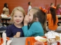First-grade students Brooklyn Vernon and Liddie Burtin have lunch at Earlington Elementary School (Hopkins High School). Cafeteria expectations at the school include talking quietly and cleaning up your mess. Photo by Amy Wallot, Oct. 16, 2014