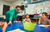 Principal Jamie Gilliam helps students get crayons as they color bookmarks for a contest at Johnson Elementary School. Gilliam said students at the school consistently meet the high expectations teachers have for them. Photo by Bobby Ellis, Nov. 18, 2016