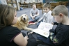 Third-grade students Alissa Kommer, Wyatt LaPradd, Corey Ringstaff and Zack Ringstaff take turns reading with Mac the dog. Librarian Rhonda Pace brought in her dog for students to read to at Ballard Elementary School 9Ballard County). \"Mac the AR reading dog\" visits the school every couple of months. According to Pace, having Mac visit brings in reluctant readers to the library.Photo by Amy Wallot, Dec. 18, 2009