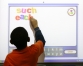 Second-grade student Robert Sydnor practices spelling using a Smart Board in the Literacy Lab at Park City Elementary (Barren County). Photo by Amy Wallot, Feb. 7, 2008