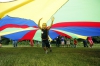 Fourth-grade student Christian Lear runs under a parachute while playing with other campers during the migrant writing camp in Madison County. Photo by Amy Wallot, June 23, 2015