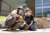 Molly Coleman and Chloe Roberts drill holes in a small log to create a mason bee house for their garden. Photo by Amy Wallot, April 28, 2015