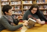Library media specialist Terri Kirk shares the book Divergent by Veronica Roth with sophomore Bethany Scott at Reidland High School (McCracken County). Kirk said fantasy and dystopian novels are currently popular with students. Photo by Amy Wallot, Dec. 11, 2012