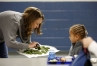 PTA president Stacy Gedritis gives a kale chip to kindergarten student Mia Lewis doing the taste test at Rosa Parks Elementary School (Fayette County). Photo by Amy Wallot, Jan. 17, 2013