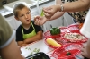 Connor Bumpas, 4, watches and learns from Janelle Mason how to prepare vegetables during the Get Going Gardening program at Lincoln Trail Elementary School (Hardin County) June 15, 2010. Photo by Amy Wallot