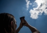 Vada Coffee, a freshman at Allen County-Scottsville High School, uses her phone and a modified solar filter to take a picture of the partial eclipse. Photo by Bobby Ellis, Aug. 21, 2017