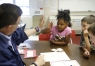 Mathematics intervention teacher Rick Reinle high-fives 1st-grade student Jasmine Morales after she answered a question about place value at Taylorsville Elementary School (Spencer County). Photo by Amy Wallot, May 6, 2013