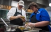 Chef Bradley Mitchell, left, a chef with the Kentucky Department of Agriculture's Kentucky Proud program, and cafeteria worker Suzie Wilson tear up smoked peppers for a sauce to be served during lunch. Photo by Bobby Ellis, Nov. 28, 2017