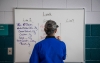 Vilma York, a cafeteria worker at Farristown Middle School, writes menus and nutritional info on a whiteboard in the cafeteria. Photo by Bobby Ellis, Nov. 28, 2017