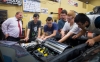 Warren County ATC Principal Eric Keeling, left, looks on as students work on the Corvette's engine. Keeling said instructors in four career pathways have incorporated project-based learning into their work on the car, and the program has benefited students academically. Photo by Bobby Ellis, May 11, 2017