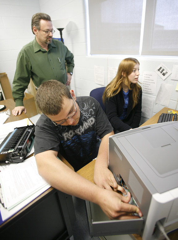 Mike Sexton, a teacher and technology coordinator at Montgomery County High School, supervises then-senior Sara Wood and then-junior Aaron Donathan as they fix a computer and printer for another teacher April 27, 2010. Districts are expanding their information technology programs to help students get skills necessary to succeed after high school. Photo by Amy Wallot