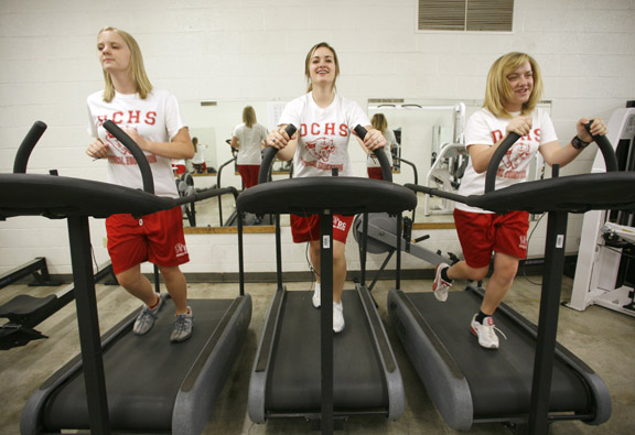 Freshman Jenny McIntosh, left, Jerrika Combs, center, and Emily Wink use treadmills that were donated to Daviess County High School by a local hospital as part of the district’s Graduation 2010 program. The program, which was originally designed to expose students to the arts, has grown to include components such as music, foreign language, literacy, critical thinking, physical and emotional health, and family and community involvement. Photo by Amy Wallot