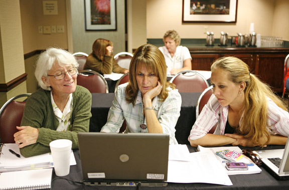 New Haven Elementary School (Boone County) art teacher Norita Alexander, left, Assistant Principal Sandy Collette, center, and special education teacher Tara Wittrock review behavior referrals for their school during the Positive Behavior Interventions and Supports (PBIS) workshop in Covington June 10, 2010. More than 20 school districts in Kentucky have implemented the PBIS model, which is designed to reduce discipline problems and increase student learning across all grade levels. Photo by Amy Wallot