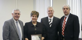 Sally Sugg is presented with the Kevin M. Noland Award, second from right, by Commissioner of Education Terry Holliday, left, and Kentucky Board of Education David Karem during the Kentucky Board of Education meeting Dec. 8, 2010 in Frankfort, Ky. Photo by Amy Wallot