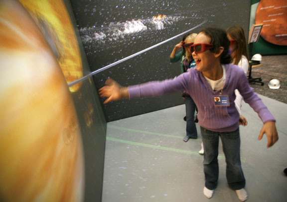 Buckhorn Elementary School (Perry County) 4th-grade student Claudia Abner reaches out to touch Jupiter in a 3-D simulation of the planets at the Challenger Learning Center of Kentucky in Hazard Dec. 3, 2010. Photo by Amy Wallot