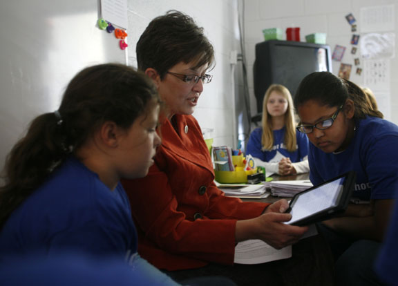 Surrounded by students Teah Burden, left, Kassidy Weedman, right, and Makayla Johnson, far right, Diane Tindle reads "A Christmas Carol" from an iPad to her 4th-grade class at William H. Natcher Elementary School's (Cloverport Independent) Blue Ribbon School celebration Dec. 9, 2010. The story was followed-up with a worksheet and a written response for the students to complete. Photo by Amy Wallot