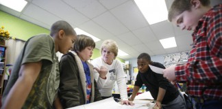 Deborah Cathcart works with 5th-grade students Michael Carter, left, Wyatt Gray, center, Davion Radford, right, and Kolby Morris, far right, on identifying and correcting problem areas with their on-demand writing pieces at Lacy Elementary School (Christian County) Feb. 2, 2011. Lacy Elementary is a 2010 Distinguished Title I School. Photo by Amy Wallot