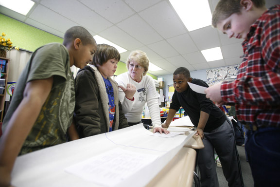 Deborah Cathcart works with 5th-grade students Michael Carter, left, Wyatt Gray, center, Davion Radford, right, and Kolby Morris, far right, on identifying and correcting problem areas with their on-demand writing pieces at Lacy Elementary School (Christian County) Feb. 2, 2011. Lacy Elementary is a 2010 Distinguished Title I School. Photo by Amy Wallot