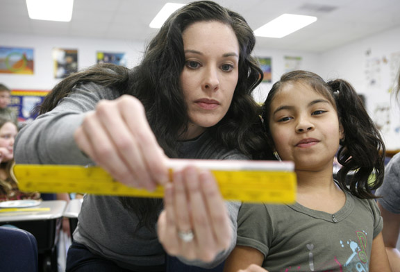 Science teacher Jaime Quattrocchi helps 4th-grade student Erin Lincoln measure the amount of chocolate chips she collected from a cookie at Sutton Elementary School (Owensboro Independent) Feb. 4, 2011. As part of their lesson about rocks, minerals and the Earth's resources, the students did a "Mining for Minerals" lab where they "mined" chocolate chips from cookies. Sutton Elementary is a 2010 Distinguished Title I School. Photo by Amy Wallot