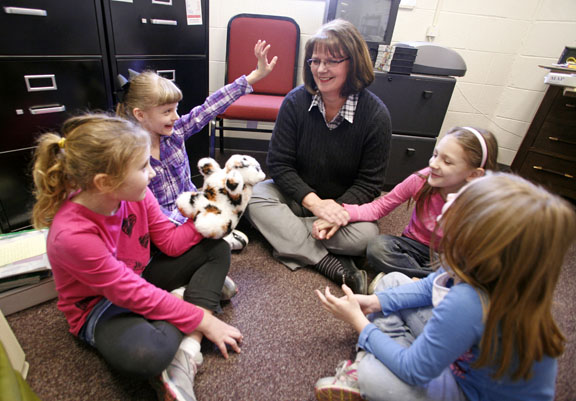 Crittenden County Elementary School counselor Trudy Bramblett talks with 2nd-grade students Lily Atchison, Lera Adams, Felonie Little and Jalaine Noel on the floor of her office Feb. 23, 2011. Atchison is holding the I Care Cat puppet that Bramblett uses with students to help them open up and express themselves. Photo by Amy Wallot