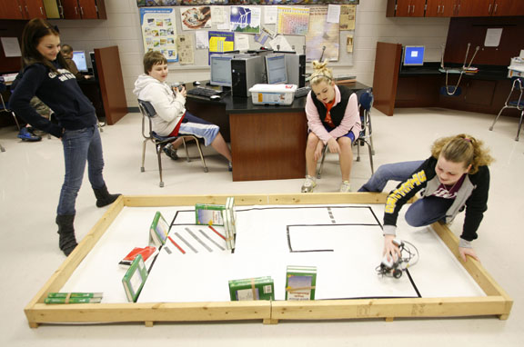 Sixth-grade students Hayden Miles, Jordan Williams and Brooklynn Jessup watch as Sarah Armstrong attempts to get her robot through a course during Bill Kunnecke's Introduction to Mobile Robotics class at North Marshall Middle School (Marshall County) Feb. 23, 2011. Photo by Amy Wallot