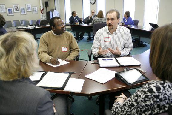 Felix Akojie, member of the Paducah Independent Board of Education, and Bryan Regenauer, an Oldham County parent, discuss goals for gifted students with Henderson County High School principal Kim Marshall and Southside Elementary School (Shelby County) principal Susie Burkhardt during the Kentucky Department of Education Gifted Advisory Council meeting March 2, 2011. Photo by Amy Wallot