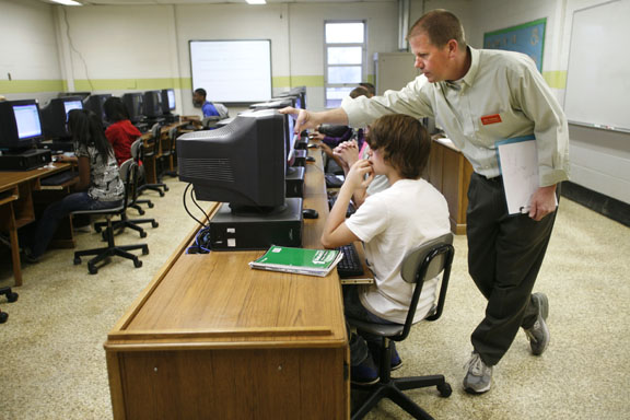 Bill Johnson helps freshman Hubert Gibbs during his Algebra I lab at Hopkinsville High School (Christian County). The students were using the Cognitive Tudor software. Johnson served in the Navy for 10 years. After later working in the private sector, he completed the Troops to Teachers program to earn his teacher certification. Photo by Amy Wallot; April 2011