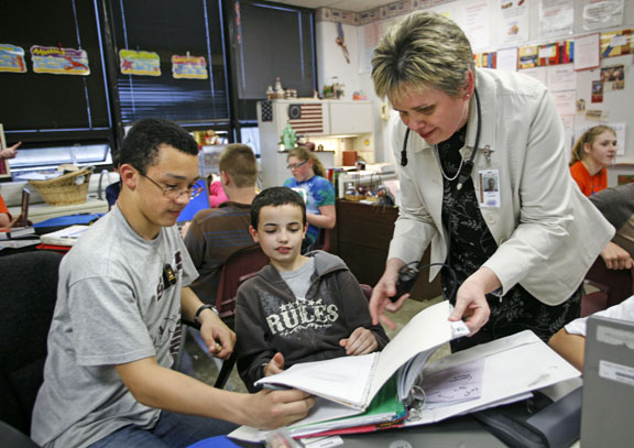 Marie Cavanah helps 7th-grade students Michael Dotson and Dylan Cobb with class work at South Middle School (Henderson County). Photo by Amy Wallot, April 2011