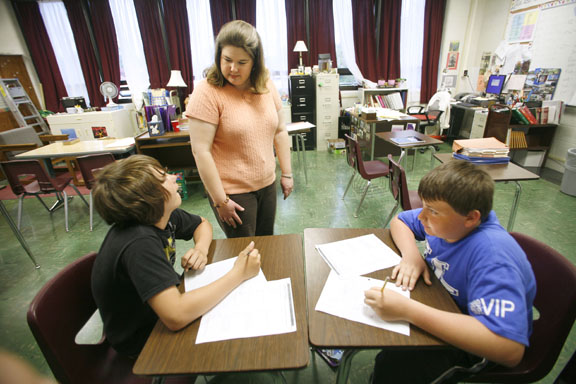 Bethany Harper helps 7th-grade students Bryce Knight and Taylor Douglas with their mathematics work at South Middle School (Henderson County). Students at the school are assessed three times a school year to help track their progress. Photo by Amy Wallot, April 2011