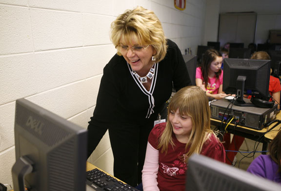 Library media specialist Lorena Webb helps 3rd-grade student Savannah Blanton with her PowerPoint about the Liberty Bell at Waco Elementary School (Madison County). The students were learning how to use PowerPoint by creating a presentation about a national monument. Photo by Amy Wallot, April 2011