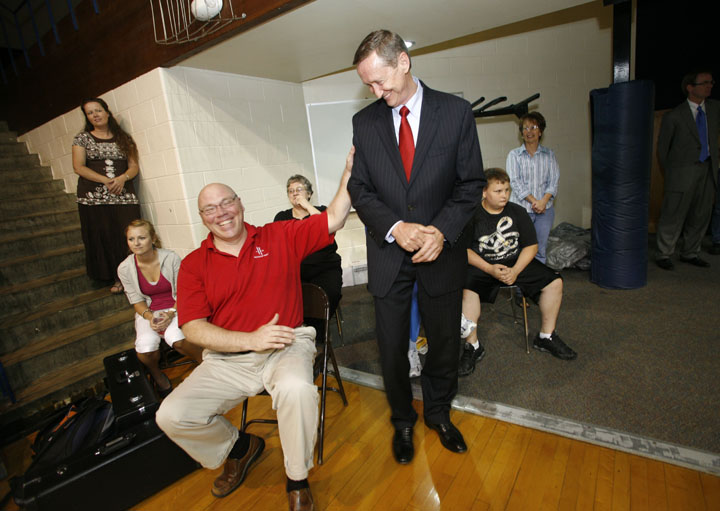 Sixth-grade social studies teacher Tracy Gabbard, left, jokes with Superintendent Larry Hammond as they watch a students/faculty basketball game at Rockcastle County Middle School. Photo by Amy Wallot; May 2011