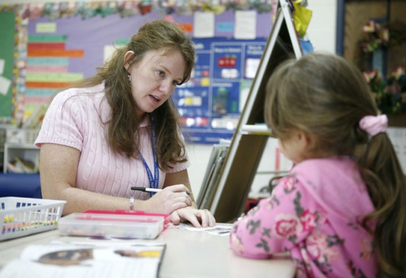 Kim Mooney helps kindergarten student Angel Bellar with an assignment about the five senses during class at Chandler's Elementary School (Logan County). Photo by Amy Wallot, Sept. 8, 2011