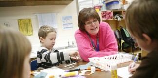 Susan Meadows sits with Christopher Empson and a small group of students practicing writing and scissor work during her preschool class at Caldwell County Primary School. Photo by Amy Wallot, Nov. 15, 2011